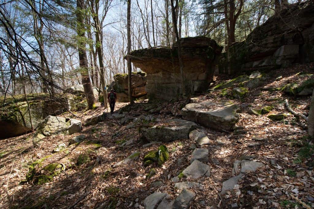 a hiker navigates the large rock formations near the Loyalsock Trail