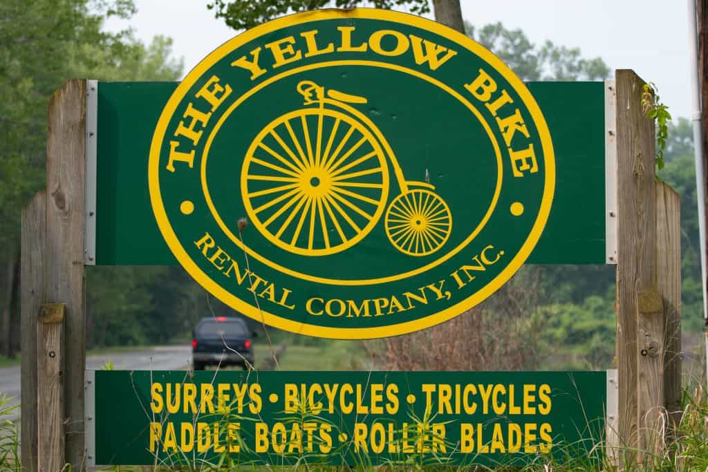 The yellow and green Yellow Bike Rental Company Inc rents surreys, bicycles, tricycles, paddle boats and roller blades