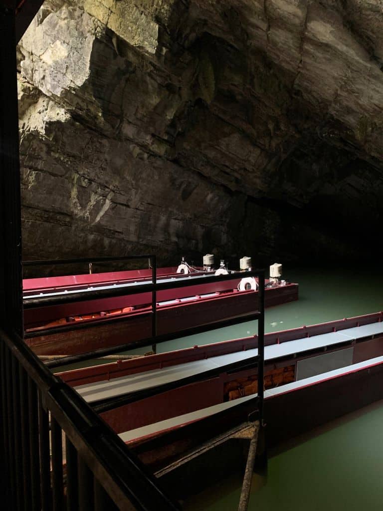 Red flat bottomed boats sit at the entrance of Penn's Cave, waiting to be filled for tours, one of the best things to do in State College when the weather is less than ideal.
