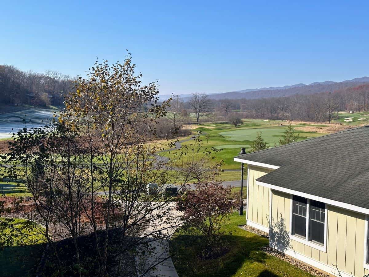 Scenic balcony view overlooking the vibrant greens of the Bedford Springs golf course, with rolling Pennsylvania hills in the distance.